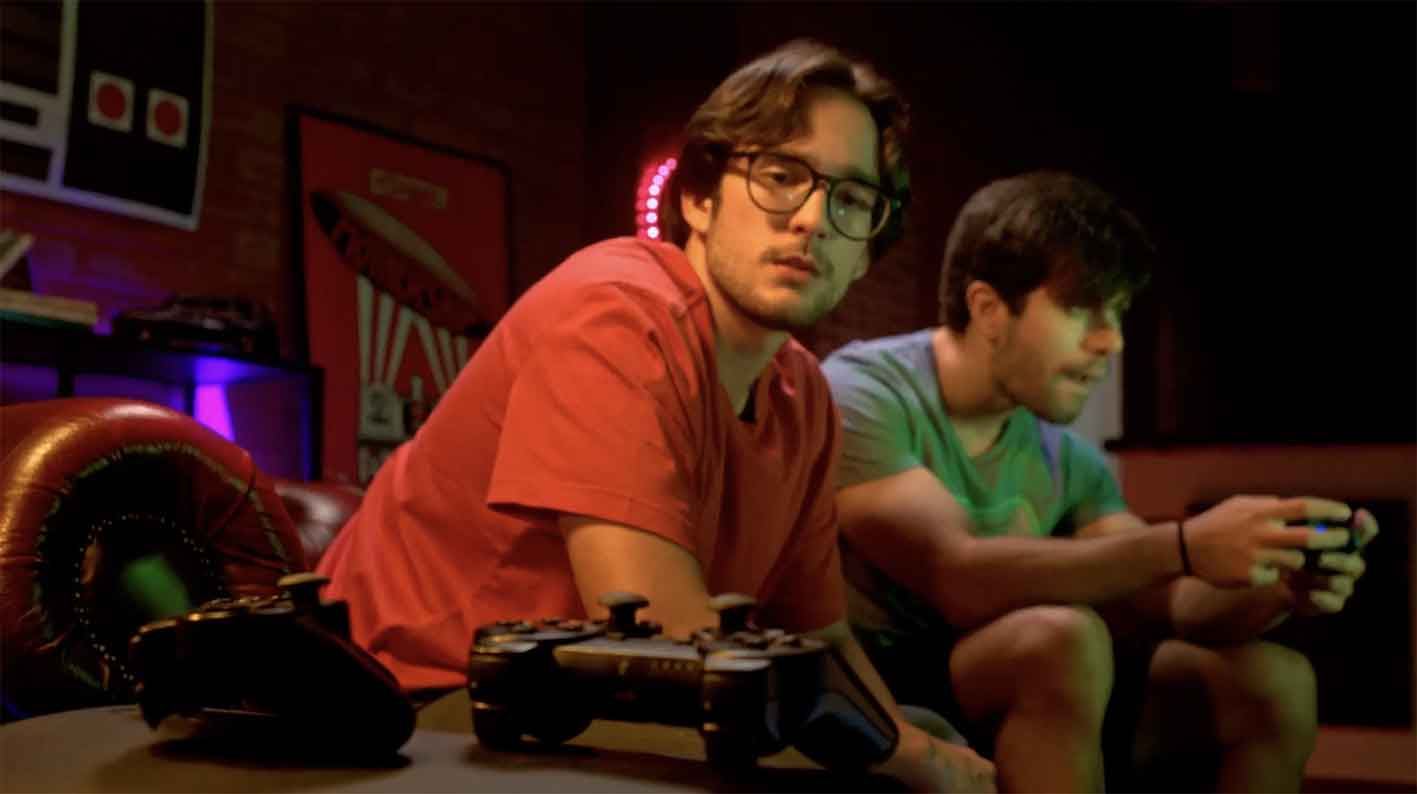 Dois jovens a jogar consola numa sala com luz quente, spot OLX